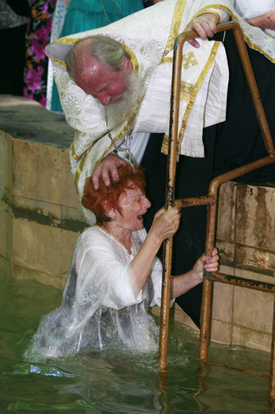 An orthodox priest consecrates water from the Chulym river during a ceremony marking adoption of Christianity, outside Nazarovo town, some 200 km (124 miles) west of the Siberian city of Krasnoyarsk, July 28, 2010. Russia officially celebrated a new holiday on Wednesday marking its conversion to Christianity in 988, the latest Kremlin boost to an Orthodox Church that has grown increasingly powerful since the fall of Communism. [Photo/Agencies]