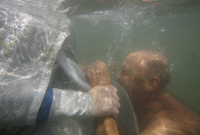 An orthodox priest consecrates water from the Chulym river during a ceremony marking adoption of Christianity, outside Nazarovo town, some 200 km (124 miles) west of the Siberian city of Krasnoyarsk, July 28, 2010. Russia officially celebrated a new holiday on Wednesday marking its conversion to Christianity in 988, the latest Kremlin boost to an Orthodox Church that has grown increasingly powerful since the fall of Communism. [Photo/Agencies]