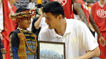 A student presents a souvenir to Chinese basketball star and Houston Rockets center Yao Ming (R) during a charity basketball match for Yao Foundation Charity Tour in Taipei, southeast China's Taiwan, July 28, 2010.