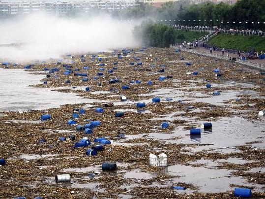 Chemical buckets have polluted the water after floods washed them into the Songhuajiang River July 28 in Jilin Provence. [Xinhua] 