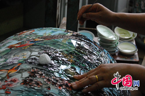Artists then take the pieces and paint them with colored enamel, filling in the spaces between the copper outlines. 
