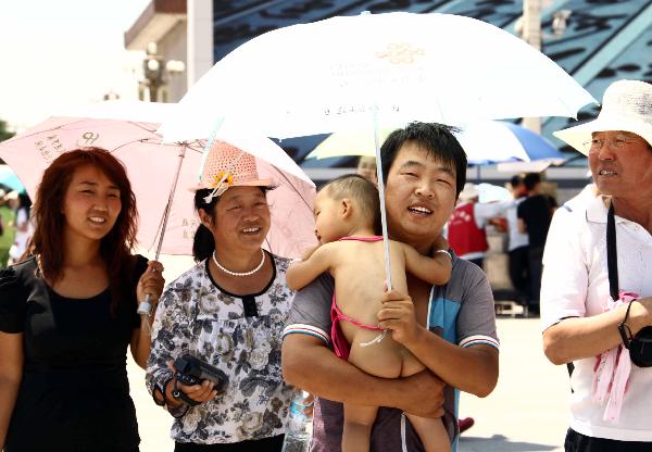 Visitors from Hebei Province walk at Tian'anmen Square in Beijing, capital of China, July 5, 2010. Chinese meteorological authority said Monday hot weather continues to scorch many parts of the country. The highest temperature of Beijing reached 40.3 degrees Celsius on Monday.  [Xinhua] 