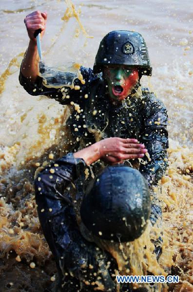 Two soldiers practise fighting skills during a psychological training at an army training field in Guangzhou, capital of south China's Guangdong Province, July 28, 2010, before the coming 83rd anniversary of the founding of the People's Liberation Army (PLA) which falls on August 1. 