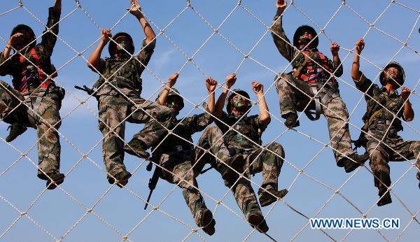 Soldiers practise climbing skills during a psychological training at an army training field in Guangzhou, capital of south China's Guangdong Province, July 28, 2010, before the coming 83rd anniversary of the founding of the People's Liberation Army (PLA) which falls on August 1. (