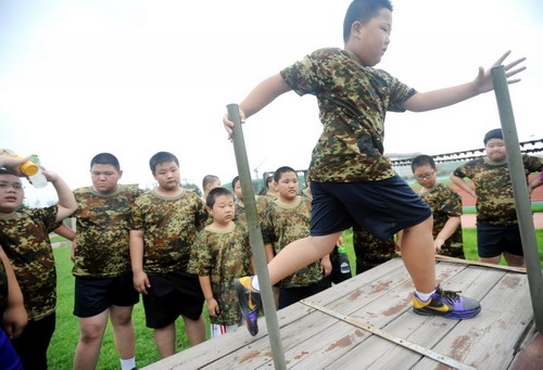 A boy is doing physical fitness training at the camp in Shenyang, capital of northeast China&apos;s Liaoning province on July 29, 2010.[Xinhua]