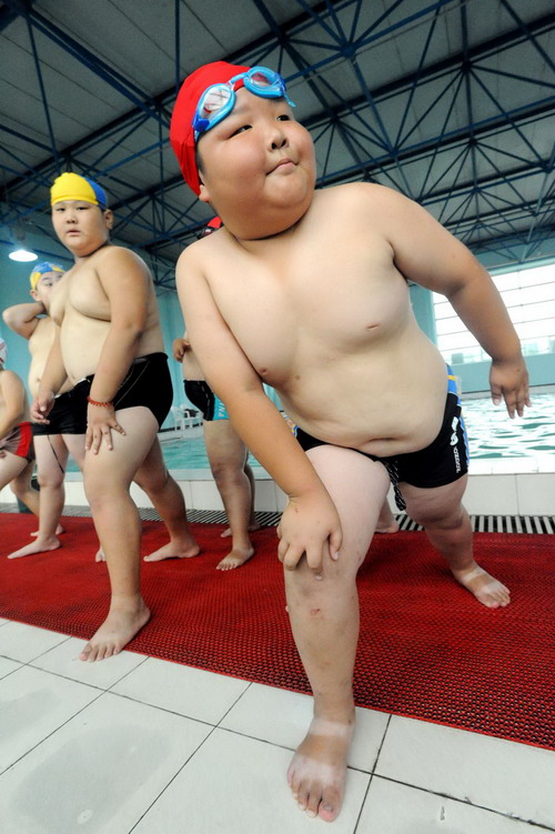  Boys warm up before jumping into the swimming pool for exercises at the training camp in Shenyang, capital of northeast China&apos;s Liaoning province on July 29, 2010.[Xinhua]