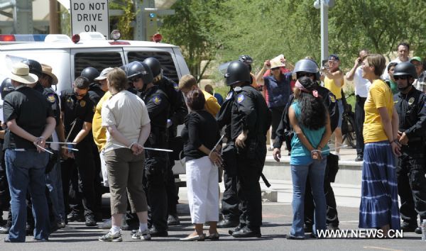 Police arrest protestors during a demonstration against Arizona&apos;s controversial Senate Bill 1070 immigration law in downtown Phoenix, Arizona, the United States, July 29, 2010. The immigration law takes effect in Arizona on Thursday with some key portions blocked by U.S. District Court Judge Susan Bolton. [Xinhua]