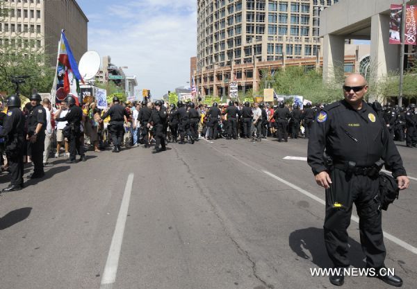 Police stand guard as protestors demonstrate against Arizona&apos;s controversial Senate Bill 1070 immigration law in downtown Phoenix, Arizona, the United States, July 29, 2010. The immigration law takes effect in Arizona on Thursday with some key portions blocked by U.S. District Court Judge Susan Bolton. [Xinhua]