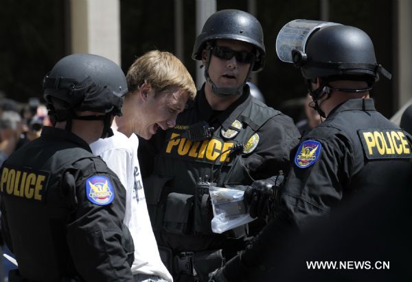 Police arrest a protestor during a demonstration against Arizona&apos;s controversial Senate Bill 1070 immigration law in downtown Phoenix, Arizona, the United States, July 29, 2010. The immigration law takes effect in Arizona on Thursday with some key portions blocked by U.S. District Court Judge Susan Bolton. [Xinhua]