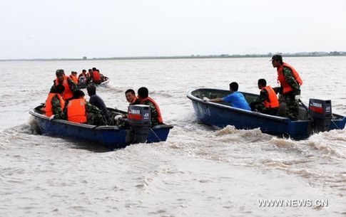 Workers head for a river fork on speed boats to set up defensive nets to block barrels in Zhaoyuan section of the Songhua River, northeast China's Heilongjiang Province, July 30, 2010. Heilongjiang Province has dispatched soldiers and workers to establish six points on the Songhua River to block the chemical containers, which were swept into the river by floods two days ago in Yongji County of Jilin Province. [Li Yong/Xinhua]