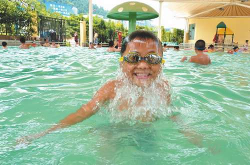 Children enjoy the cool in a swimming pool in Beijing. North China including Beijing and Tianjin has seen muggy weather for the past week with the minimum temperature a notch above average at 35 degrees Celsius. The meteorological observatory said rains were expected later this week.