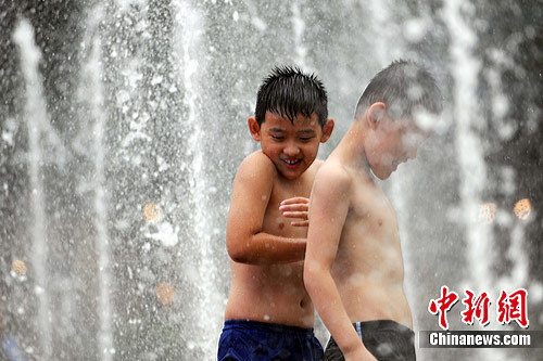 Children play in a fountain in downtown Beijing. North China including Beijing and Tianjin has seen muggy weather for the past week with the minimum temperature a notch above average at 35 degrees Celsius. The meteorological observatory said rains were expected later this week. 