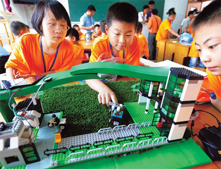 Participants fix a low-carbon school gate model during a creative competition in Taizhou, East China's Jiangsu Province, on Wednesday. [China Daily]
