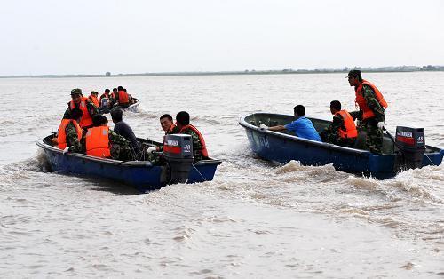 Emergency staffers nevigate boats in the Songhua River on Friday, July 30, 2010, searching for the chemical-filled barrels that were swept into the river by flood waters two days ago. [Photo: Xinhua]