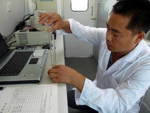 A technician tests a water sample from the Songhua River on Friday, July 30, 2010. [Photo: Xinhua]