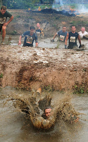 A competitor emerges from muddy water during the Tough Guy Challenge, at South Perton Farm, in Wolverhampton, England, July 25, 2010.