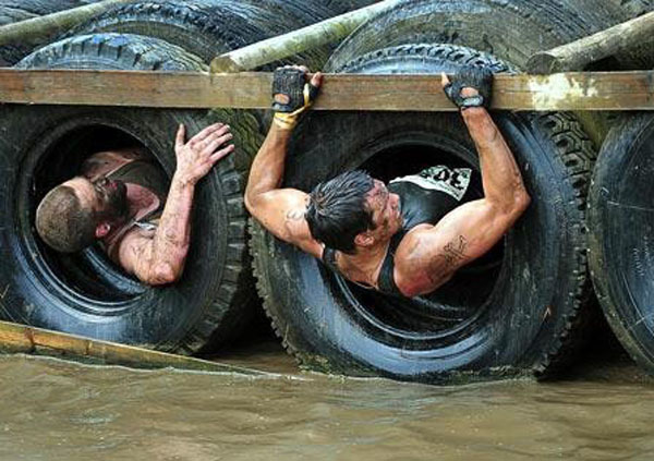 Racers compete at a tunnel obstacle during the Tough Guy 2010 race on July 25, 2010.