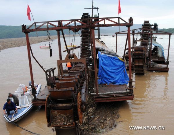 Two heavy vessels are dragged to safe place on the Songhua Lake, northeast China's Jilin Province, July 31, 2010.