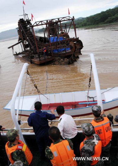 A heavy vessel is drew to the bank by a boat on the Songhua Lake, northeast China's Jilin Province, July 31, 2010. 