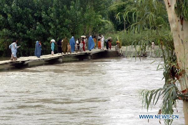 People migrate with their belongings as their houses were flooded following heavy monsoon rains in northwest Pakistan's Pabbi, on July 31, 2010.