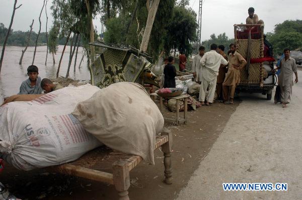 People prepare to migrate with their belongings as their houses were flooded following heavy monsoon rains in northwest Pakistan's Pabbi, on July 31, 2010.