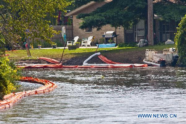 Containment booms float on the surface of the Kalamazoo River near an oil spill site in Marshall, Michigan, the United States, July 31, 2010. The U.S. Environmental Protection Agency (EPA) and Enbridge are working to contain the spill and cleanup the damage to local water and wildlife.