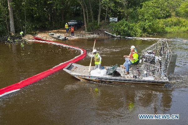 Workers for the U.S. Environmental Protection Agency (EPA) deliver more containment booms on the Kalamazoo River near an oil spill site in Marshall, Michigan, the United States, July 31, 2010.