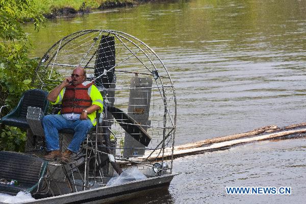 A worker for the U.S. Environmental Protection Agency (EPA) sits on an airboat on the Kalamazoo River near an oil spill site in Marshall, Michigan, the United States, July 31, 2010.