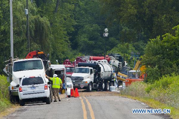 Workers manuver heavy equipment near an oil spill site outside Marshall, Michigan, the United States, July 31, 2010.