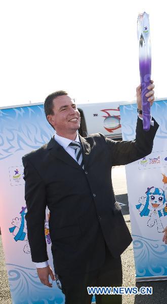 Danyor Loader, Olympic ambassador of New Zealand holds the torch during the flame arrival ceremony at the airport in Auckland, New Zealand, July 31, 2010. The torch for the Singapore 2010 Youth Olympic Games journey arrived in Auckland on Saturday.