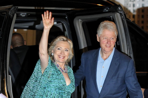 U.S. Secretary of State Hillary Clinton waves beside her husband former U.S. President Bill Clinton as they arrive for an after-party for their daughter Chelsea in Rhinebeck, New York July 30, 2010.