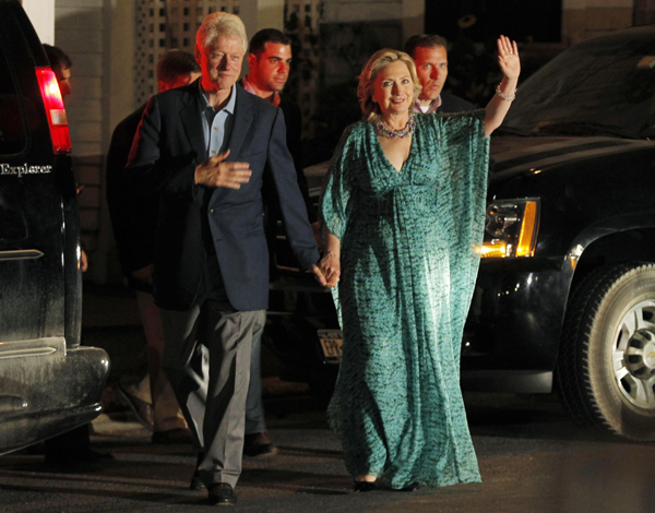 U.S. Secretary of State Hillary Clinton waves beside her husband former U.S. President Bill Clinton as they leave an after-party for their daughter Chelsea in Rhinebeck, New York July 30, 2010.