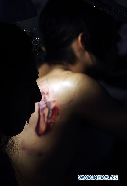 A tattoo artist works on a participant during the 2010 Tattoo Exposition held in Taipei, southeast China&apos;s Taiwan, Aug. 1, 2010. The 2010 Tattoo Exposition, one of the biggest tattoo event in Asia, closed in Taipei on Sunday. [Xinhua]