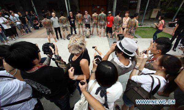 Spectators take pictures at a tattoo show during the 2010 Tattoo Exposition held in Taipei, southeast China&apos;s Taiwan, Aug. 1, 2010. The 2010 Tattoo Exposition, one of the biggest tattoo event in Asia, closed in Taipei on Sunday. [Xinhua] 