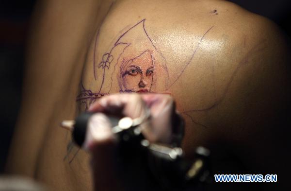 A tattoo artist works on a participant during the 2010 Tattoo Exposition held in Taipei, southeast China&apos;s Taiwan, Aug. 1, 2010. The 2010 Tattoo Exposition, one of the biggest tattoo event in Asia, closed in Taipei on Sunday. [Xinhua]