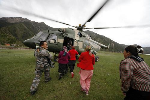 Women and children are seen being rescued onto a military helicopter in Kuche County, northwest China&apos;s Xinjiang Uygur Autonomous Region, Aug. 1, 2010. Mountain torrents have trapped more than 1,000 people in a remote valley since Thursday after heavy rains hit northwest China&apos;s Xinjiang Uygur Autonomous Region. Rescue efforts are still under way. [Xinhua]