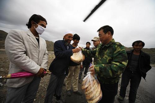 Food and water is served out to people in Kuche County, northwest China&apos;s Xinjiang Uygur Autonomous Region, Aug. 1, 2010. [Xinhua]