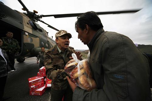 Food and water is served out to people in Kuche County, northwest China&apos;s Xinjiang Uygur Autonomous Region, Aug. 1, 2010. [Xinhua]