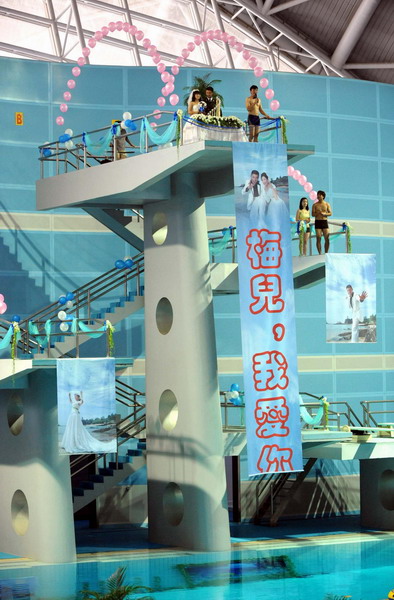 A wedding ceremony is held on the 10-meter platform, with a banner saying &apos;I love you, Mei Er (bride&apos;s nickname)&apos; at the Natatorium of Nanjing Olympic Sports Center, August 1, 2010. [Xinhua]