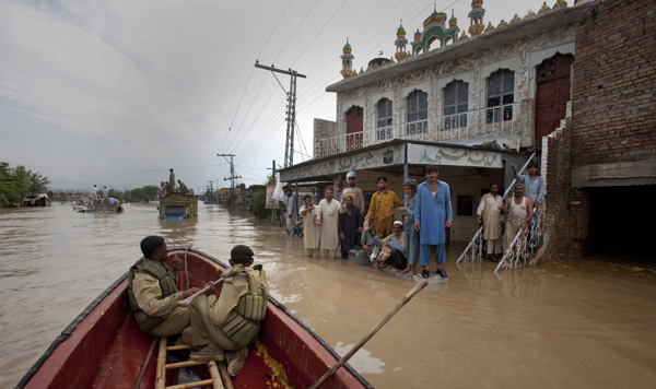 Residents taking shelter in a mosque wait to be evacuated as army soldiers move past in a boat in Nowshera, located in Pakistan&apos;s northwest Khyber-Pakhtunkhwa Province July 31, 2010. [Xinhua]