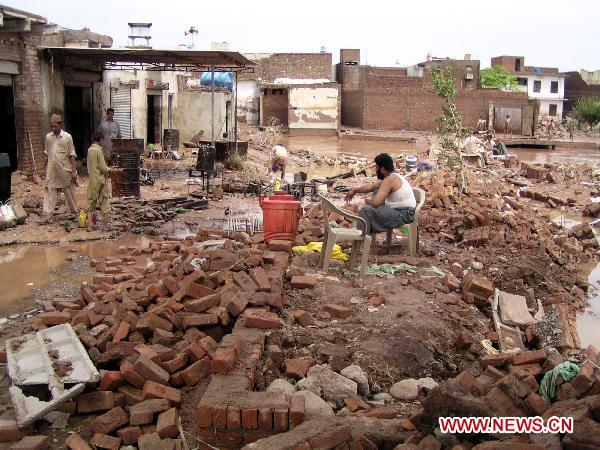 People clear debris as their houses were flooded following heavy monsoon rains in northwest Pakistan&apos;s Nasir-Bagh on Aug. 1, 2010. The current horrible wave of floods and landslides triggered by torrential monsoon rains has killed more than 900 people in Pakistan while 1 million people have become homeless as the flood is now hitting western and southern parts of the country. [Saeed Ahmad/Xinhua]