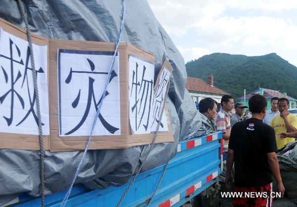 Relief supplies are served out to people in Huadian, northeast China&apos;s Jilin Province, Aug. 1, 2010. Rain-triggered flood swept several townships in Huadian City since July 27. Measures have been taken to carry on post-disaster reconstruction. [Xinhua]