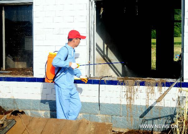Anti-epidemic personnel disinfects in Huadian, northeast China&apos;s Jilin Province, Aug. 1, 2010. Rain-triggered flood swept several townships in Huadian City since July 27. Measures have been taken to carry on post-disaster reconstruction. [Xinhua]