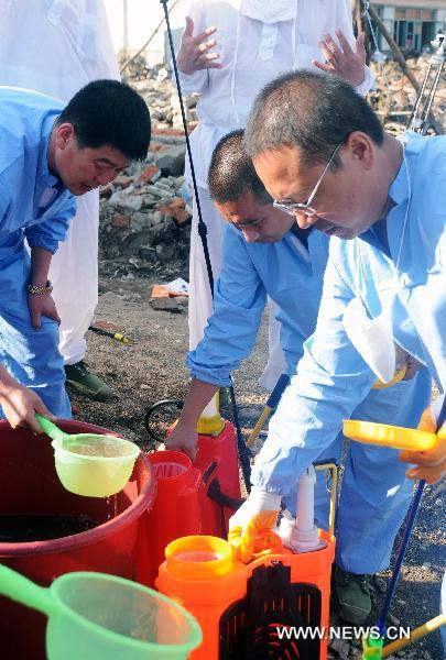 Anti-epidemic personnels disinfect in Huadian, northeast China&apos;s Jilin Province, Aug. 1, 2010. Rain-triggered flood swept several townships in Huadian City since July 27. Measures have been taken to carry on post-disaster reconstruction. [Xinhua]