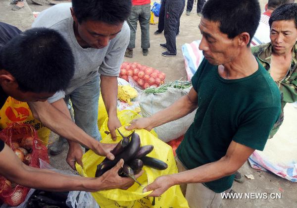 Relief supplies are served out to people in Huadian, northeast China&apos;s Jilin Province, Aug. 1, 2010. Rain-triggered flood swept several townships in Huadian City since July 27. Measures have been taken to carry on post-disaster reconstruction. [Xinhua]
