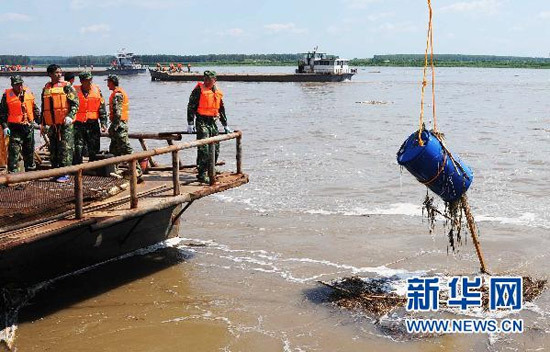 Rescue workers retrieve chemical barrels in Wukeshu Port of Yushu City, Jilin Province, on July 29. 