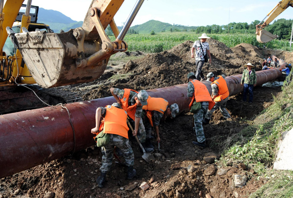 Soldiers race against time to repair a water pipeline which was damaged by torrential rain in Tonghua, an industrial city in Northeast China&apos;s Jilin province August 2. [Xinhua]