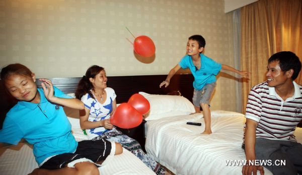 Ten-year-old Xiao Han plays balloons with his sister, 13-year-old Xiao Fen and their parents in a hotel in Dongguan, south China&apos;s Guangdong Province, July 31, 2010. [Xinhua]