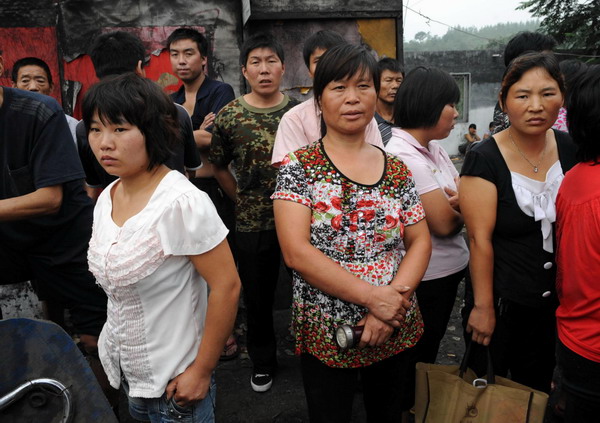 Families of the miners anxiously wait outside the Sanyuandong Coal Mine in Baiping Township, Dengfeng City, Henan province August 2. [Xinhua]