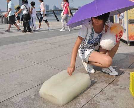 Blocks of ice were placed at the Bund Sunday to help visitors stay cool in the extreme heat when temperatures reached nearly 39 C. [Global Times]